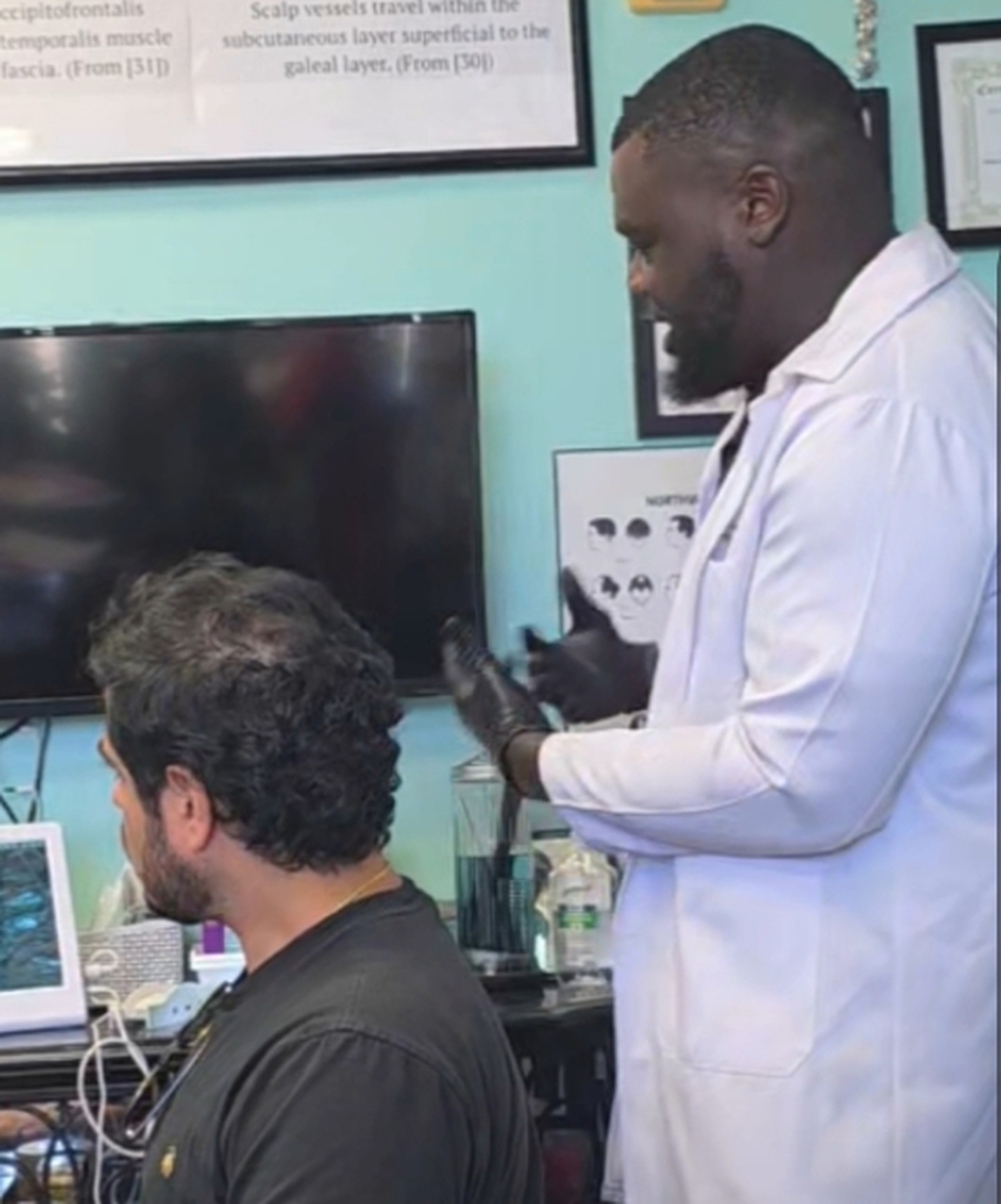 Tessy Anifowoshe Jr., Mr. RSMP™, using a scalp analysis device during a hair investigation